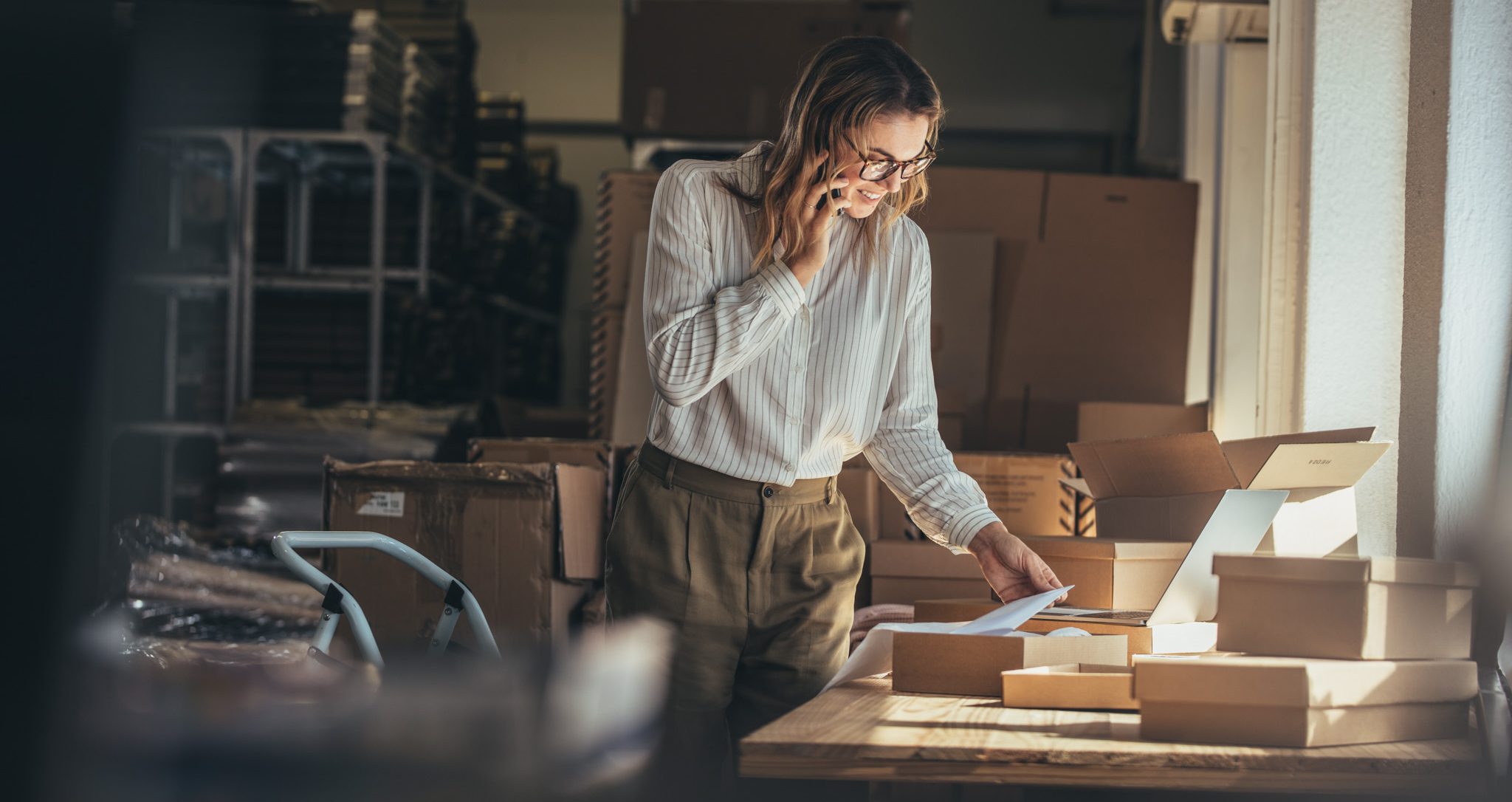 Woman small business is on the phone in her store