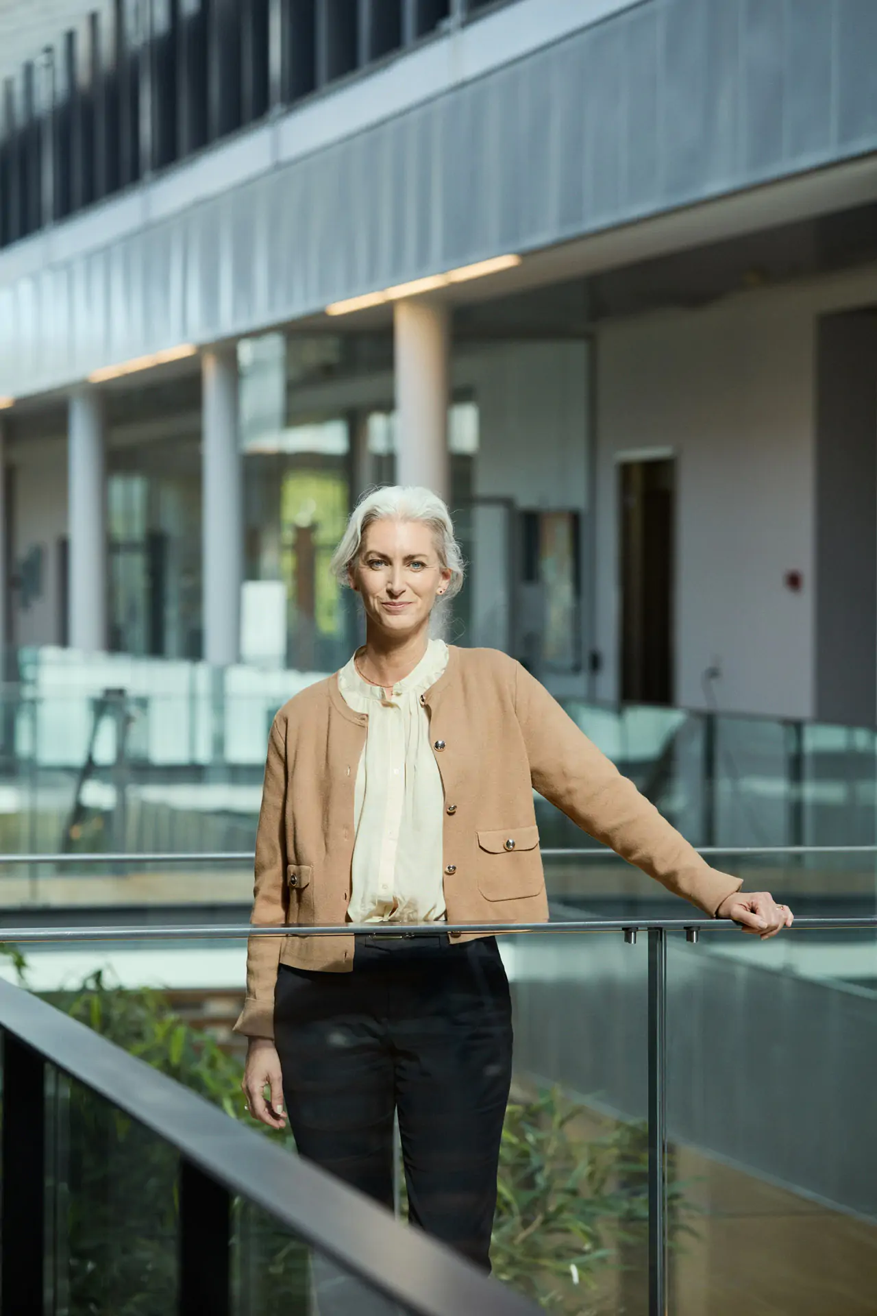 white hair woman standing on an office bridge