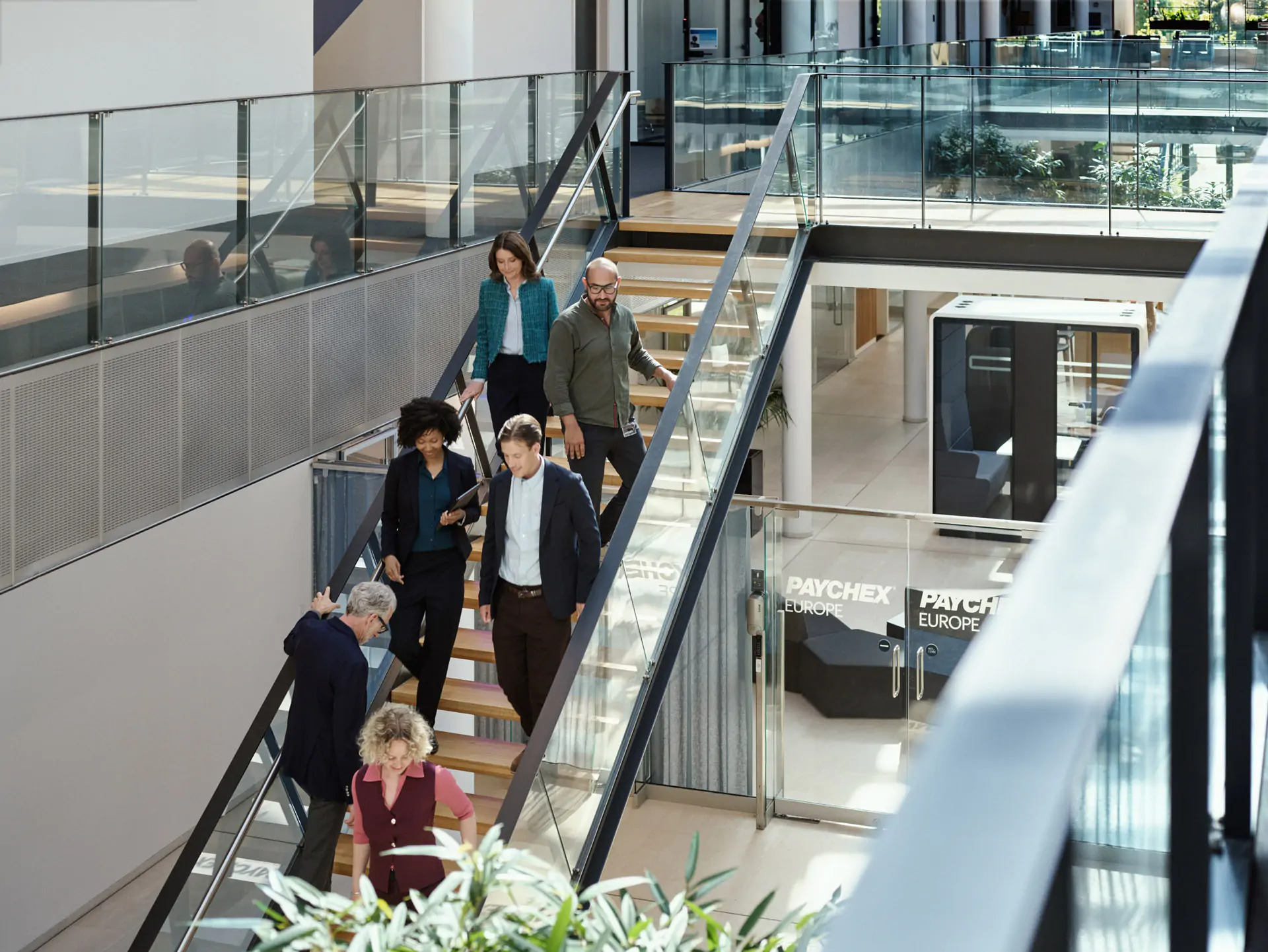 Menschen gehen im Büro die Treppe hinunter