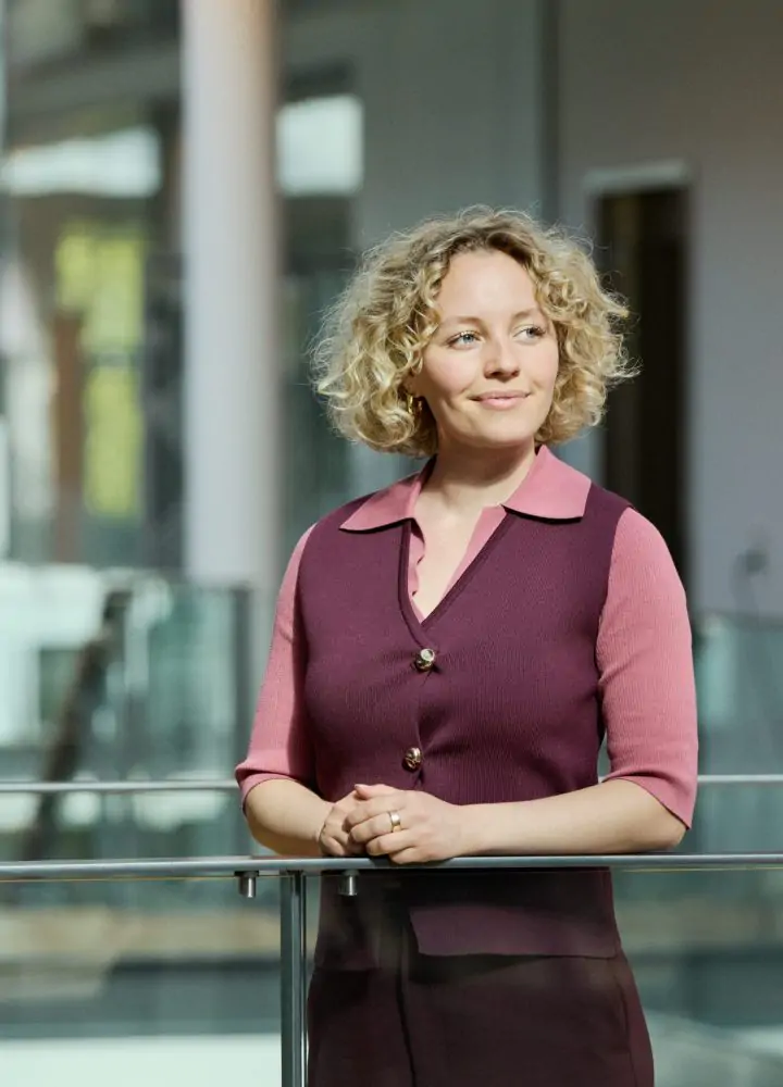 Eine Frau steht auf einer Gangbrücke im Büro