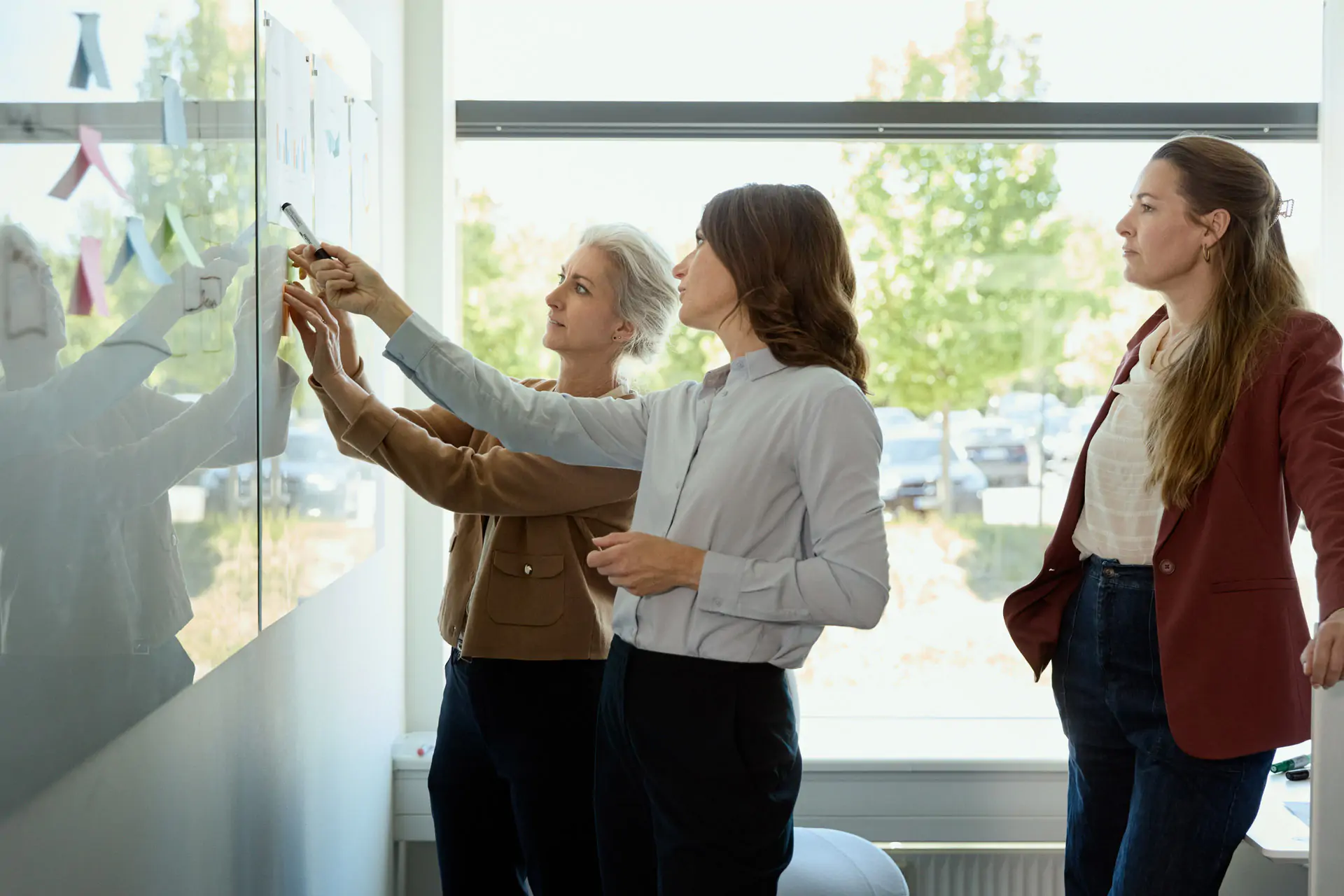 women standing at a white board